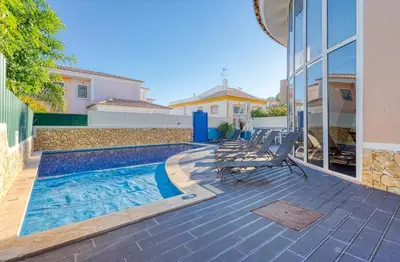 a swimming pool with chairs next to a building at Full private 300sqm Villa Jacuzzi Heated Pool Ideal & quiet location in Albufeira