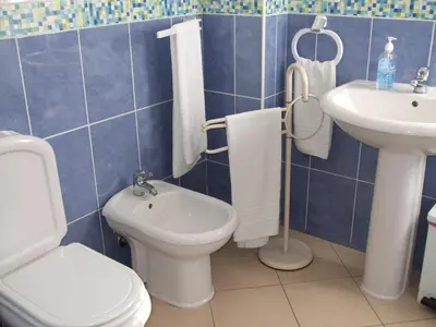 a blue tiled bathroom with a toilet and a sink at Hotel Adelaide in Faro