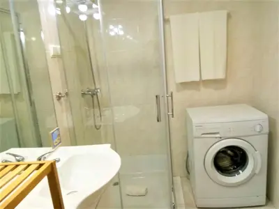 a bathroom with a washing machine and a sink at Sol europa- Vista Mar, 150mt Praia, Wifi in Quarteira