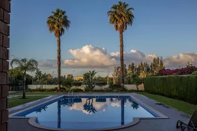 a swimming pool in a yard with palm trees at Apartamento Vista Golfe Mar Vilamoura in Vilamoura