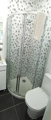 a bathroom with a shower with a toilet and a sink at Sleep & Go Faro Airport Guest House in Faro