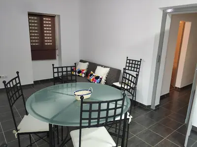 a room with a table and chairs and a couch at Sleep & Go Faro Airport Guest House in Faro