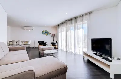 a living room with a couch and a flat screen tv at AL - Apartamento Terracos da Falesia in Vilamoura