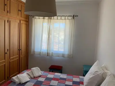 a bedroom with a bed with two towels on it at Guest House Alfarrobeiras in Albufeira