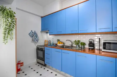 a kitchen with blue cabinets and a sink at Seaview Penthouse in Algarve with Spacious Terrace in Quarteira