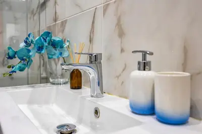 a bathroom sink with a faucet and a bottle of soap at Seaview Penthouse in Algarve with Spacious Terrace in Quarteira