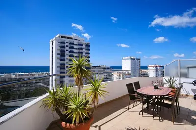 a balcony with a table and chairs and a view of the ocean at Seaview Penthouse in Algarve with Spacious Terrace in Quarteira
