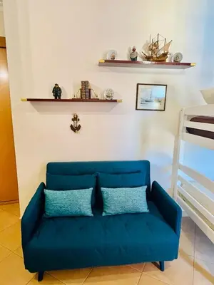 a blue couch in a living room next to a bed at Albufeira Villa Santa Maria in Albufeira