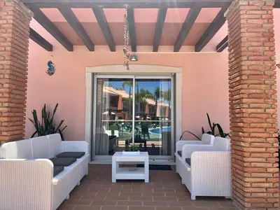 a patio with white furniture and a window at Albufeira Villa Santa Maria in Albufeira