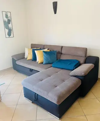 a couch in a living room with blue and yellow pillows at Albufeira Villa Santa Maria in Albufeira
