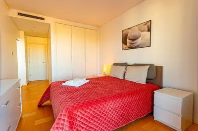 a bedroom with a bed with a red bedspread at VilamouraSun Aquamar 518 - Fantástico Vista in Vilamoura