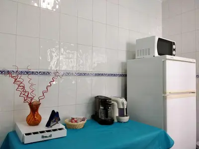 a kitchen with a coffee maker on a table next to a refrigerator at Oceanides Beachfront Apartments in Quarteira