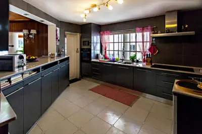 a large kitchen with black cabinets and a window at Villa Monaco in Faro