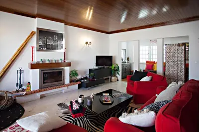 a living room with red furniture and a fireplace at Villa Monaco in Faro