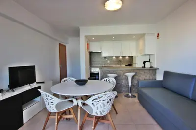 a living room with a couch and a table and chairs at Amendoeiras I - Central Vilamoura in Vilamoura
