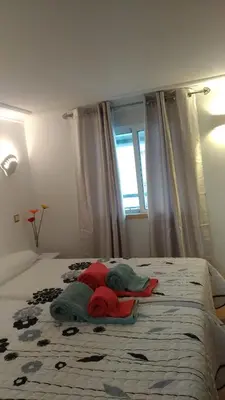 a bedroom with a bed with blankets and a window at Apt Cardoso 3 ao lado da Praia Peneco in Albufeira