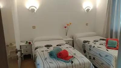 a small bedroom with two beds with towels on them at Apt Cardoso 3 ao lado da Praia Peneco in Albufeira
