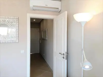 a hallway with a white door and a lamp at T1 PraiaMar RC com Ar-Condicionado in Quarteira