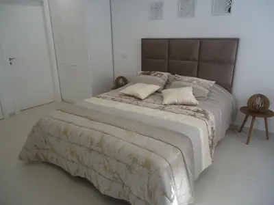 a bedroom with a large bed with two pillows on it at VIVENDA L'OLIVIER in Quarteira
