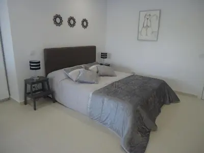 a bedroom with a bed and a side table at VIVENDA L'OLIVIER in Quarteira