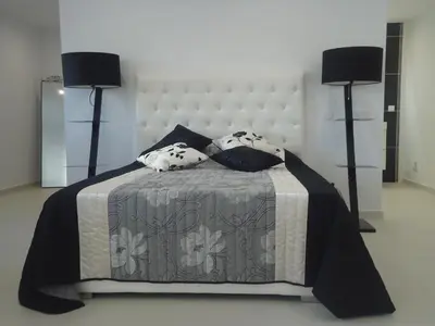 a bedroom with a large bed with two lamps at VIVENDA L'OLIVIER in Quarteira
