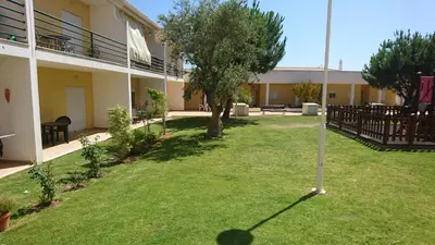 a yard of a building with a tree in it at Apartamento T2 Encosta sao jose in Albufeira