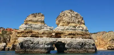 an arch in a rock formation in the water at Apartamento T2 Encosta sao jose in Albufeira