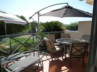 a patio with a table and chairs and an umbrella at Corcovada 37 in Albufeira