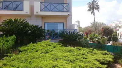 a house with palm trees in front of it at Corcovada 37 in Albufeira