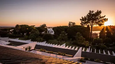a sunset over a garden with white roofs at Quinta do Lago Country Club in Quinta do Lago