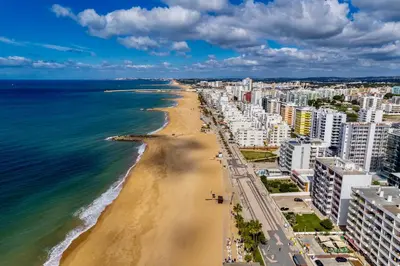 a view of a beach with buildings and the ocean at Renovated Vilamoura Penthouse Near Marina & Beach in Vilamoura