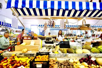 a group of people in a market with fruits and vegetables at Renovated Vilamoura Penthouse Near Marina & Beach in Vilamoura