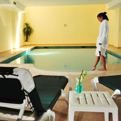 a woman standing in front of a swimming pool at Vila Gale Marina in Vilamoura