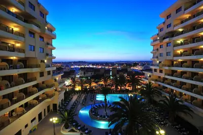 an aerial view of a hotel with a swimming pool at night at Vila Gale Marina in Vilamoura