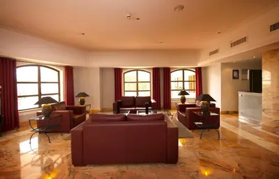 a living room with couches and tables and windows at Vila Gale Cerro Alagoa in Albufeira