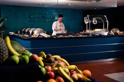 a chef standing in a kitchen with a bunch of fruit at Vila Gale Cerro Alagoa in Albufeira
