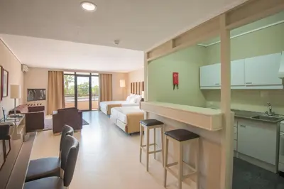 a hotel room with a bed and a kitchen at Vila Gale Ampalius in Vilamoura