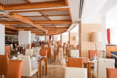 a restaurant with wooden ceilings and tables and chairs at Vila Gale Ampalius in Vilamoura