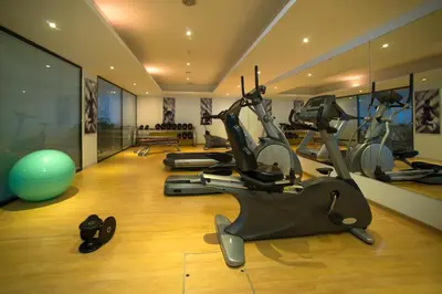 a gym with several treadmills and exercise bikes at Vila Gale Ampalius in Vilamoura