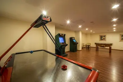 a room with a ping pong table and a video game at Vila Gale Ampalius in Vilamoura