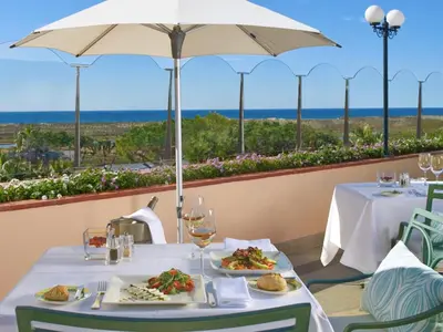 a table with two plates of food and an umbrella at Hotel Quinta do Lago in Quinta do Lago