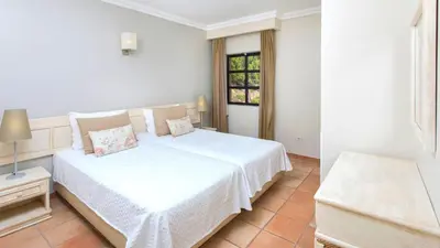 a bedroom with a white bed and a window at Alfagar Village in Albufeira