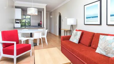 a living room with a red couch and a table at Alfagar Village in Albufeira
