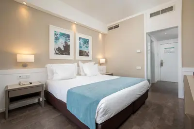 a hotel room with a bed and a balcony at AP Eva Senses in Faro