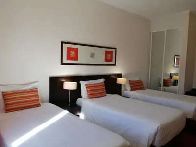 a bedroom with a bed with two pillows and two lamps at Hotel Monaco in Faro