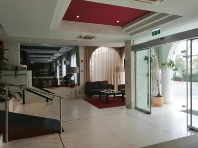 a hotel room with a desk with a television and a chair at Hotel Monaco in Faro
