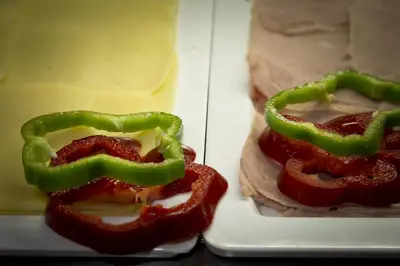 a refrigerator with peppers and meat and cheese at Hotel Baia Grande in Albufeira