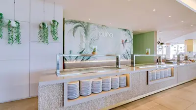 a restaurant with a counter with plates on it at Auramar Beach Resort in Albufeira