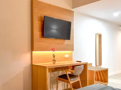 a room with a desk with a television on a wall at Hotel Sol e Mar Albufeira - Adults Only in Albufeira