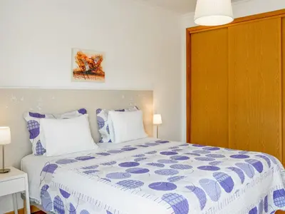a bedroom with a bed with a blue and white comforter at Villa Villa Pescada by Interhome in Albufeira